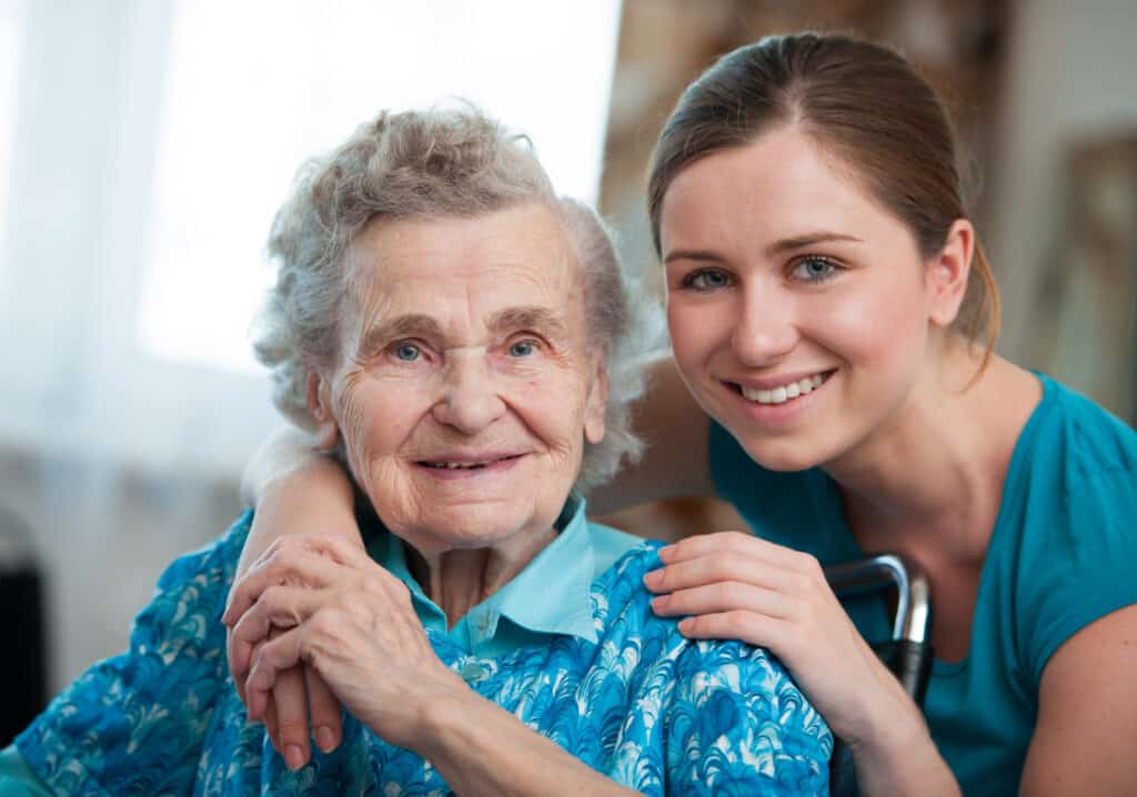 A young woman embraces an elderly woman, showing love and care.