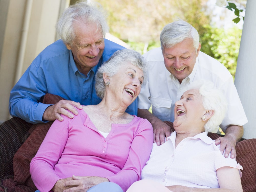 Three elderly individuals sharing a joyful moment, expressing happiness through laughter and smiles.