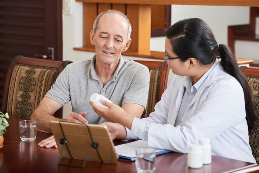 A senior man and caregiver engaged in a conversation about the benefits of offering life care services.