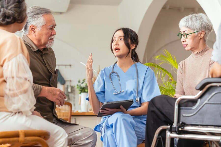 nurse communicating with group of seniors about life care services